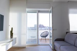 ein Wohnzimmer mit einem Sofa und einer Glasschiebetür in der Unterkunft 7th floor apartment in Foggia