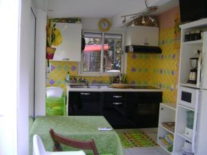 eine kleine Küche mit einem Tisch und einem Waschbecken in der Unterkunft Gite à Bandol in Bandol
