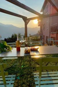 a table with a bottle and glasses on top of a house at Il Mallo Verde - Lake Como B&B in Mandello del Lario