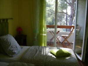 ein Schlafzimmer mit einem Bett, einem Fenster und einem Stuhl in der Unterkunft Gite à Bandol in Bandol