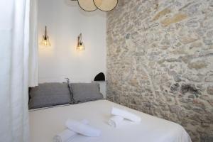 a bedroom with a stone wall and a bed at La Ciotat AUTHENTIQUE - T3 à 2 pas du port et des plages - Parking souterrain offert in La Ciotat