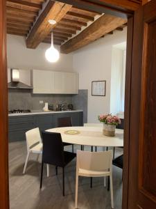 Al Vecchio Platano guest house في بيتيجليانو: مطبخ مع طاولة وكراسي وطاولة ومطبخ