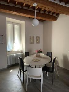 una sala da pranzo con tavolo e sedie bianchi di Al Vecchio Platano guest house a Pitigliano