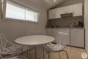 a kitchen with a white table and chairs in a kitchen at COSY LODGE TOULOUSE in Toulouse