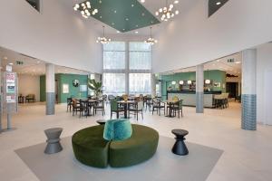 a lobby with a cafeteria with tables and chairs at Résidence services seniors DOMITYS LES EAUX VIVES in Digne-les-Bains