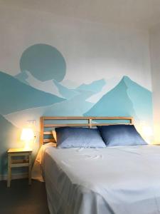 um quarto com uma cama com um mural de montanha na parede em Il Mallo Verde - Lake Como B&B em Mandello del Lario