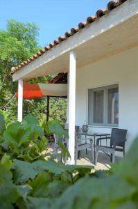a patio with two chairs and a table and an umbrella at Litochoro apartment in Estate A1 in Litochoro