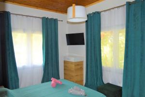 a bedroom with green curtains and a bed with a television at Litochoro apartment in Estate A1 in Litochoro