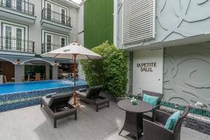 曼谷的住宿－拉普提萨利尔素坤逸通罗1，庭院配有桌椅和遮阳伞。