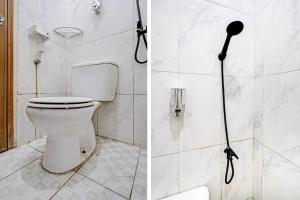 ein Bad mit Dusche, WC und Duschkopf in der Unterkunft OYO 91334 Permata Papua Guest House in Pameungpeuk