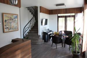 a living room with a staircase and a table and chairs at Milano Hotel in Burgas
