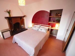 a bedroom with a bed with a red headboard and a fireplace at Il Mallo Verde - Lake Como B&B in Mandello del Lario