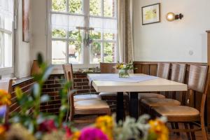 a dining room with a table and chairs and windows at Landgasthaus Berns De Bakker in Engden