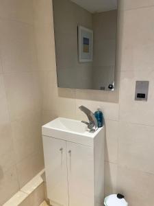 Baño blanco con lavabo y espejo en Lavender Cottage - Hillside Holiday Cottages, Cotswolds, en Warmington