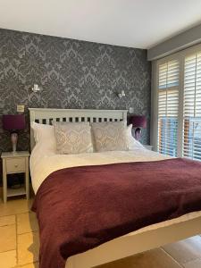 um quarto com uma cama grande e um cobertor vermelho em Lavender Cottage - Hillside Holiday Cottages, Cotswolds em Warmington