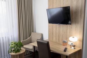 a room with a table and a television on a wall at Landgasthaus Berns De Bakker in Engden