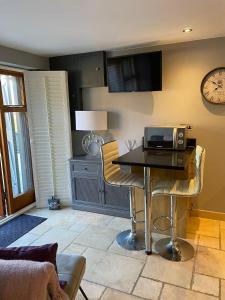 een woonkamer met een tafel en een magnetron. bij Lavender Cottage - Hillside Holiday Cottages, Cotswolds in Warmington