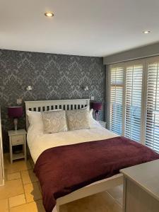 um quarto com uma cama grande e um cobertor vermelho em Lavender Cottage - Hillside Holiday Cottages, Cotswolds em Warmington