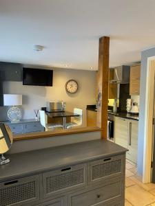 a large kitchen with a clock on the wall at Lavender Cottage - Hillside Holiday Cottages, Cotswolds in Warmington