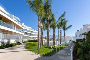 een rij palmbomen voor een gebouw bij Luxury Penthouse Large Terrace 2 Bedrooms OR79 by AORASTAY in La Cala de Mijas