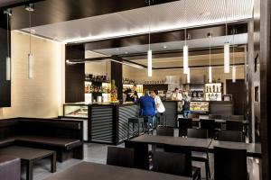 ein Restaurant mit Tischen und Leuten, die an einem Tresen stehen. in der Unterkunft Hotel Il Cantico St. Peter in Rom
