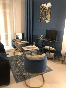 勒瓦盧瓦－佩雷的住宿－Bel appartement parisien，客厅拥有蓝色的墙壁和桌椅