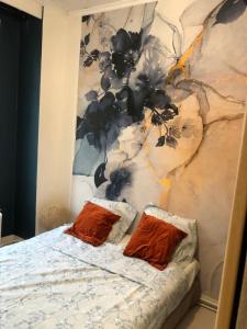 ein Bett mit zwei Kissen vor einer Wand in der Unterkunft Bel appartement parisien in Levallois-Perret