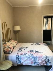 ein Schlafzimmer mit einem Bett und einer Lampe und einem Fenster in der Unterkunft Bel appartement parisien in Levallois-Perret