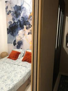 ein Bett mit zwei orangenen Kissen in einem Zimmer in der Unterkunft Bel appartement parisien in Levallois-Perret + 8 Fotos