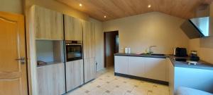 a kitchen with white cabinets and a counter top at Nazareth logement Un Magnifique logement de vacances in Bastogne +13 photos