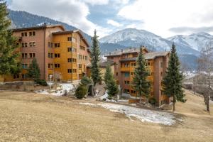 a group of buildings with trees and mountains in the background at Dorothy Sunshine in Fiesch