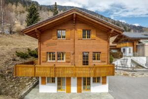 a log home with a large deck on the front at Cresta in Fiesch