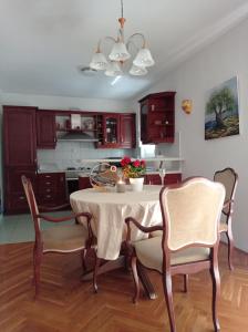 a dining room with a table and chairs and a kitchen at Apartman 4 in Rijeka