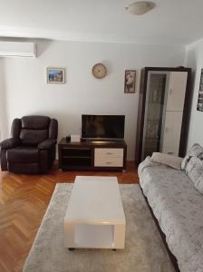 a living room with a couch and a tv at Apartman 4 in Rijeka