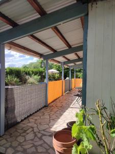 a patio with awning and pots on the side of a building at Chalet dans la Foret....Adorable 1 bedroom chalet surrounded by woodland in Pressignac