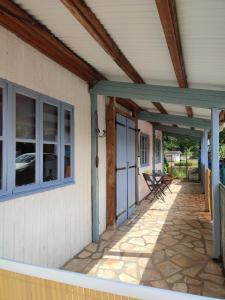a porch of a house with a patio at Chalet dans la Foret....Adorable 1 bedroom chalet surrounded by woodland in Pressignac
