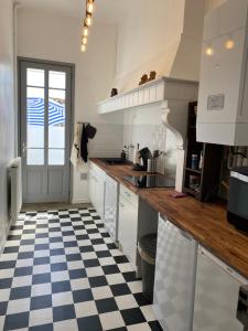 a kitchen with a black and white checkered floor at La belle Histoire in Carcassonne +16 photos