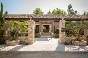 una entrada de piedra a una casa con una pared de piedra en Daluz Boutique Hotel en Preveza