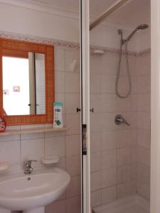 La salle de bains est pourvue d'un lavabo et d'une douche. dans l'établissement Giardino Del Sole, à Tropea