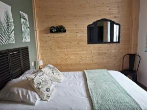 a bedroom with a white bed with a wooden wall at Gîtes ETCHE ARGUINIA in Montory +60 photos