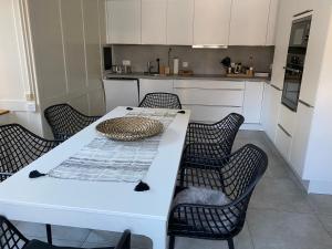 eine Küche mit einem weißen Tisch und Stühlen in der Unterkunft Ferienwohnung Blumerhaus in Mitlödi in Mitlödi