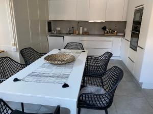 MitlödiにあるFerienwohnung Blumerhaus in Mitlödiのキッチン(白いテーブル、椅子付)