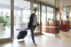 une personne se promenant dans le hall avec ses bagages dans l'établissement Hotel Re, à Lissone