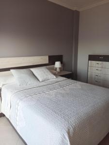 - une chambre avec un grand lit et un couvre-lit blanc dans l'établissement CASA CON ESPECTACULARES VISTAS AL MAR, à Escarabote