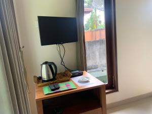 a table with a television on it next to a window at Wonder-Land Villa in Ubud