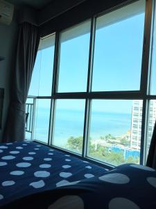 een kamer met een groot raam met uitzicht op de oceaan bij Stunning Seaview Suite in Jomtien Beach