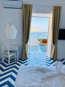 Villa Diamond Luxury Suite في بوسيتانو: غرفة نوم بسرير وطاولة ونافذة