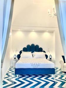 a bedroom with a large bed with a blue headboard at Villa Diamond Luxury Suite in Positano