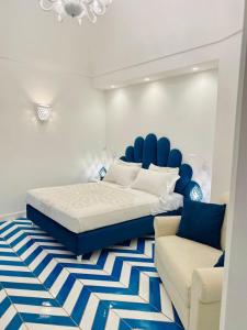 Villa Diamond Luxury Suite في بوسيتانو: غرفة نوم بسرير واريكة
