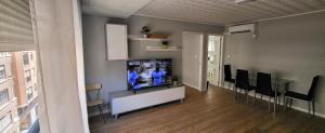 a living room with a television and a table and chairs at Tenerias 2 in Castellón de la Plana